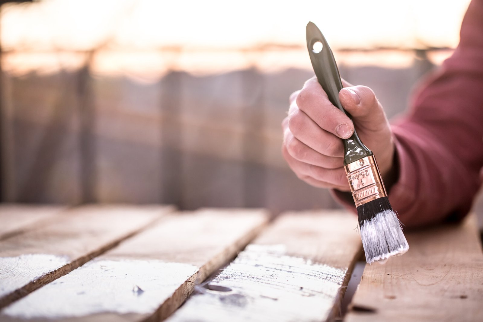 male hand paints with white paint wood painting concept close up place text scaled